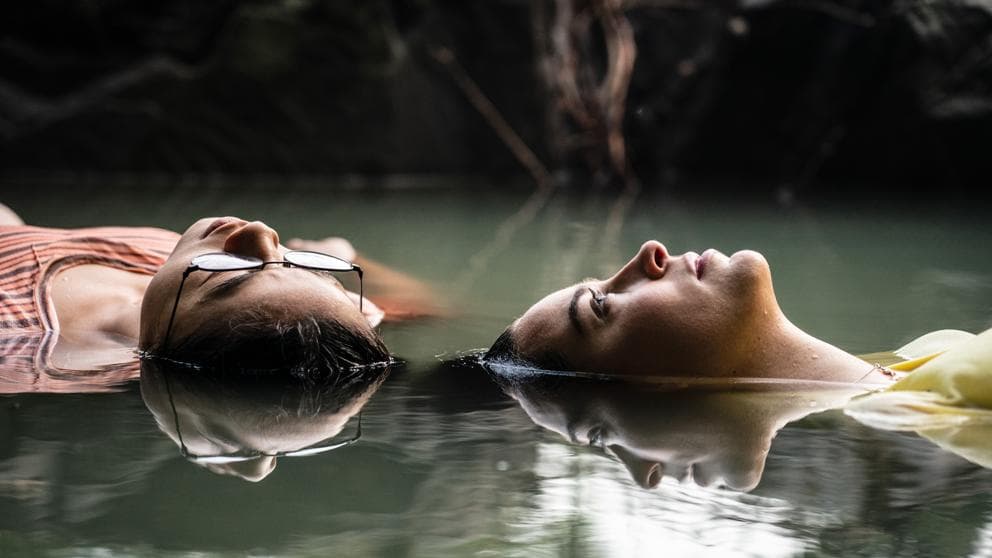 Ellie and Aster float in a water source.