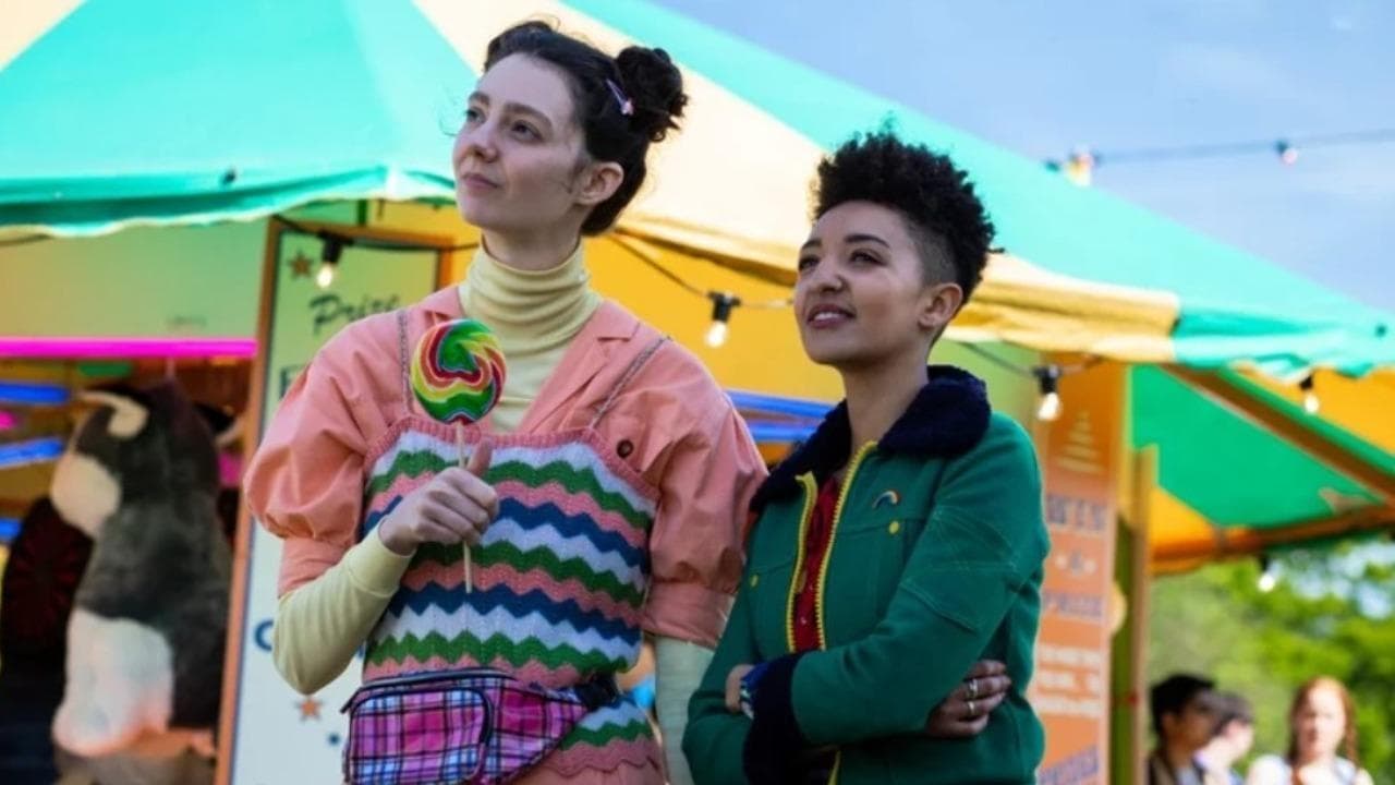 Lily and Ola are at what seems to be their school, standing side to side, looking at something, surprised.